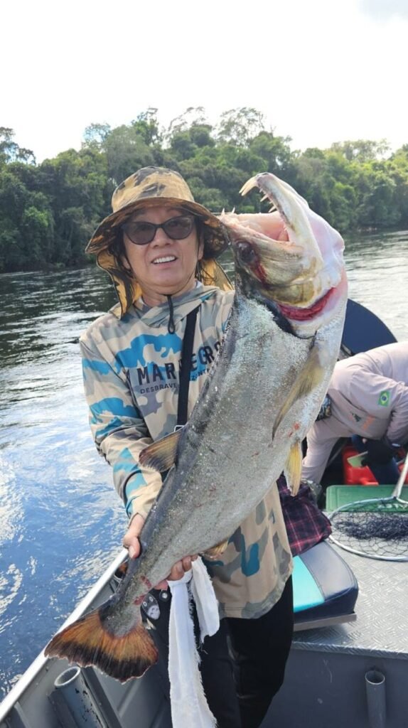 Guest holding a fish caught in the river