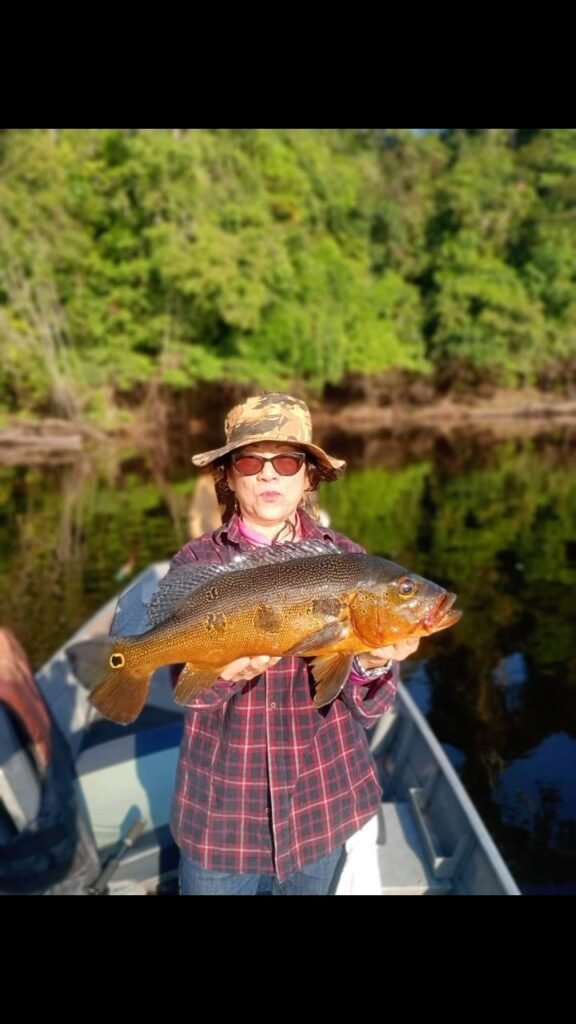 Guest holding a fish caught in the river