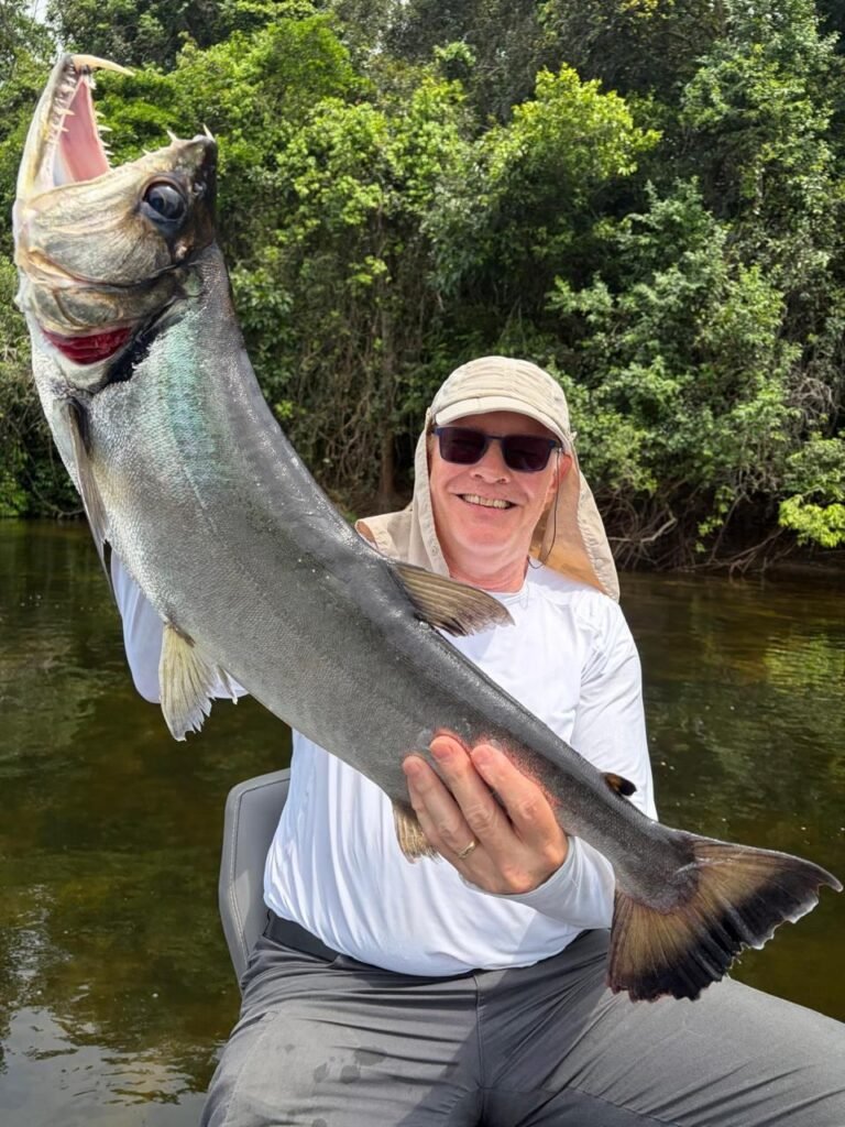 Guest holding a fish caught in the river